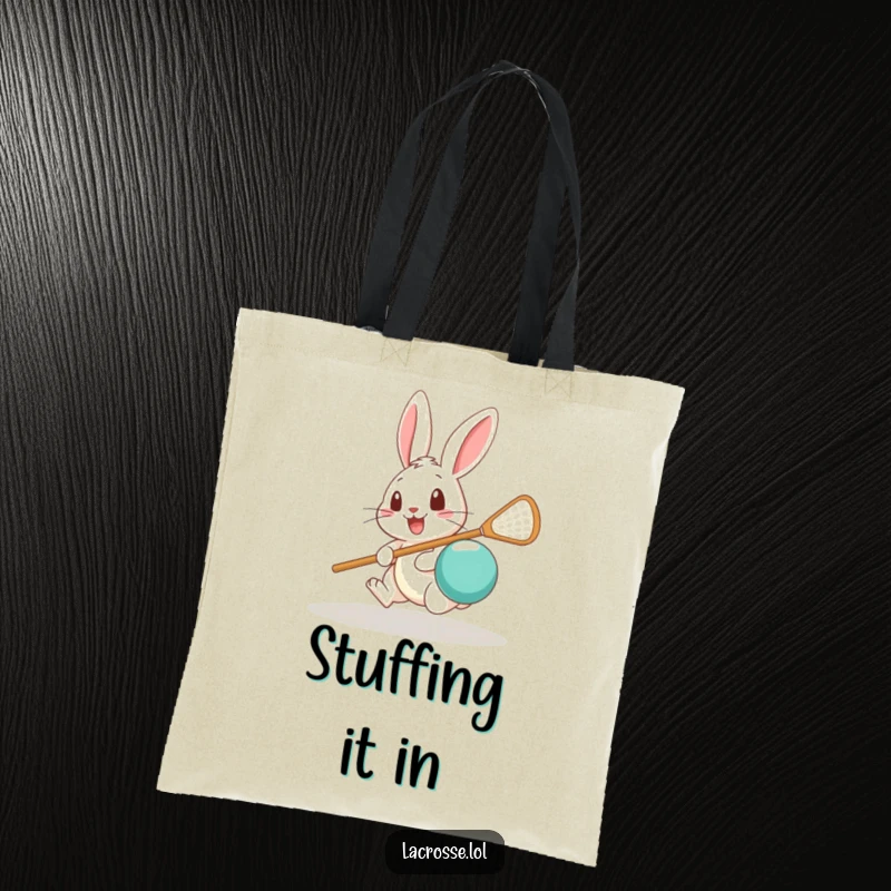 Funny tote bag showing a surprised rabbit attempting to scoop a lacrosse ball, great for carrying daily essentials.